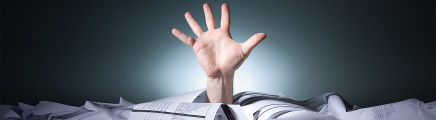 Eine Hand die aus einem Stapel Papier herausragt