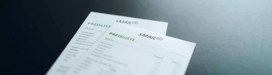 Es liegen zwei Preislisten auf denen die Preise von sMAIL stehen auf dem Tisch