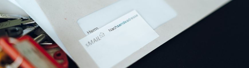 Ein Brief mit einem Kleber auf dem das sMAIL Logo ist und danaben steht 