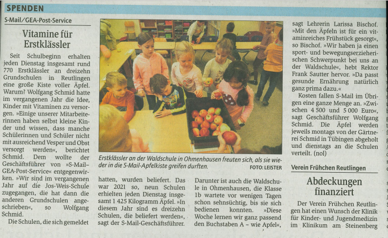 Ein Zeitungsartikel mit einem Bild auf dem Kinder &Auml;pfel aus einer Kiste rausholen