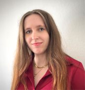 Eine Frau mit langen Haaren, die eine roten Bluse an hat