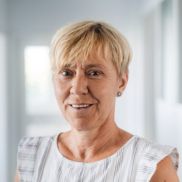 Eine Frau mit kurzen Haaren und sie hat ein weiß schwarz gesteiftes Top an