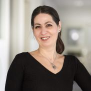 Eine Frau mit mittellangen Haaren und einem schwarzen dünnen Pullover